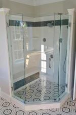 custom glass shower enclosure in room with hexagonal tiles